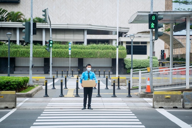 Triste hombre de negocios cargando caja después de ser despedido en la calle