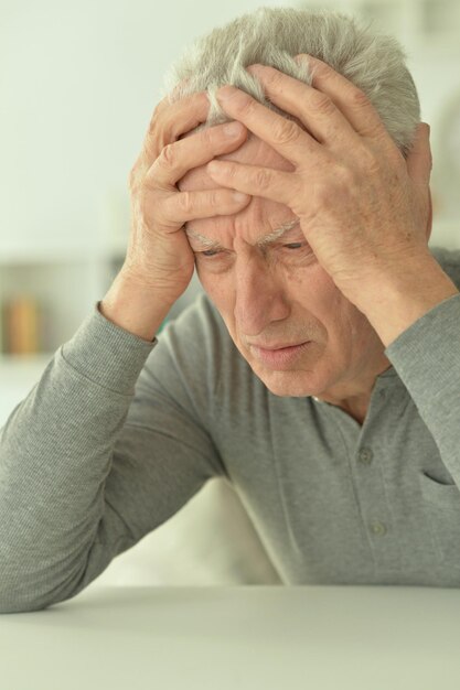 Foto triste homem sênior em casa