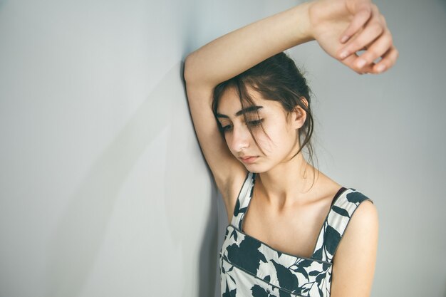 Triste joven en pared gris