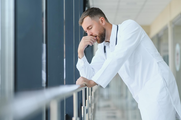 Foto triste médico parado no corredor do hospital