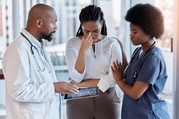 Triste médico y tableta con el médico y la mujer en el hospital para consultar los resultados o la empatía Medicina médica y malas noticias con el informe del hombre y el paciente en la clínica africana para obtener ayuda o consejo de la enfermera