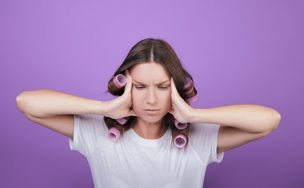 Una triste mujer de cabello castaño con rulos rosados levantó la cabeza.