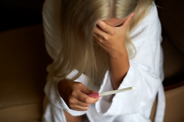 Triste mulher segurando o teste de gravidez