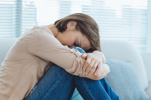 Triste mulher sentada no sofá