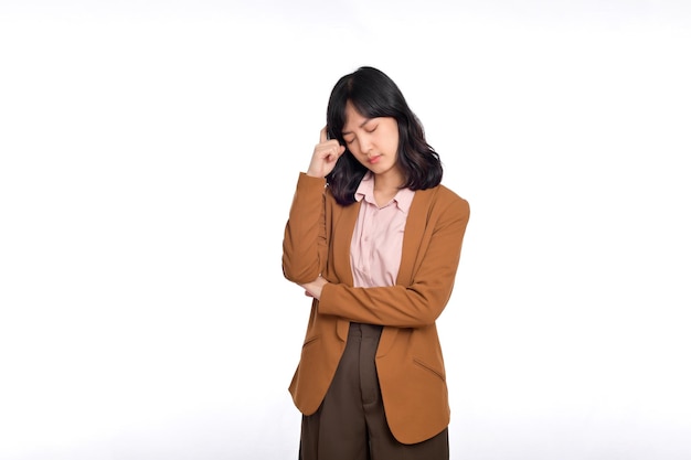 Triste oficinista mujer asiática enfurruñada y frunciendo el ceño decepcionada de pie molesta y angustiada contra el fondo blanco