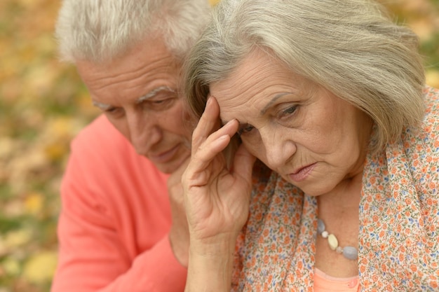 Triste pareja senior en el parque