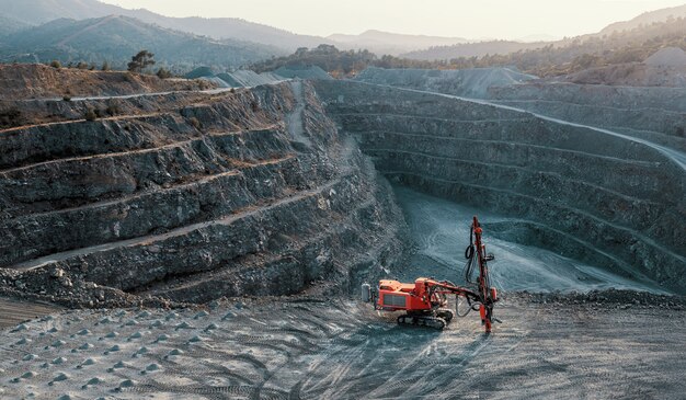 Foto triturador de pedra vermelha em um terraço de pedreira de cascalho. paisagem industrial, sem pessoas