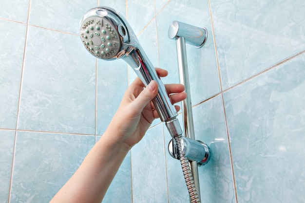 Troca de encanamento no banheiro, chuveiro de mão montado na parede e suporte para mangueira com barra deslizante ajustável em altura.