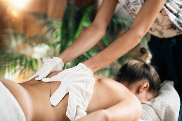 Foto trockene ayurvedische rückenmassage mit garshana-seidenhandschuhen