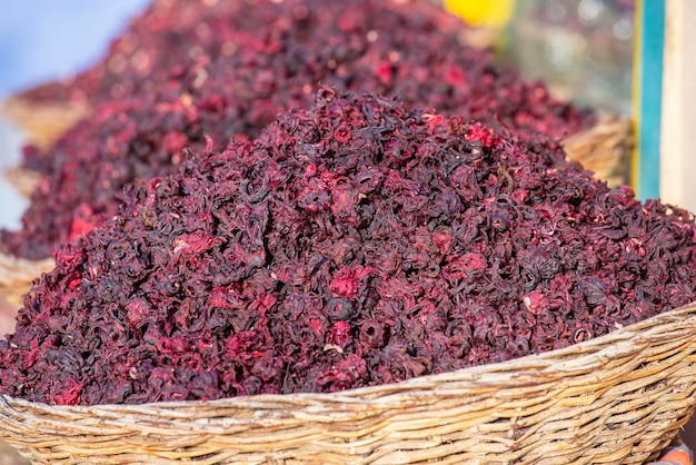 Trockene Karkade-Teeblätter im Weidenkorb auf dem Straßenmarkt Sharm el Sheikh Ägypten Trockener Kräuter-Hibiskus für Tee in Körben Arabische Kräuter auf dem traditionellen Basar