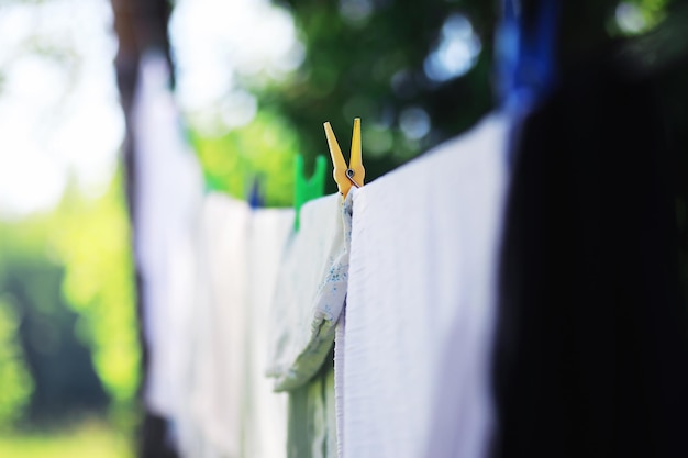 Trockene Kleidung draußen Kleidung an einem Seil Wäscheklammern an einer Wäscheleine im Sommer