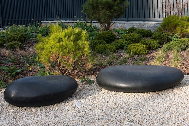 Trockene Landschaft des Zen-Gartens oder japanischer Steingarten Karesansui mit schwarzen Steinen auf weißem Kies zum Wiedererrichten ...