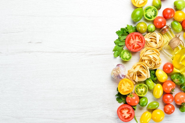 Trockene Nudeln, Tomaten, Gemüse, Öl und Zutaten, traditionelle italienische Küche, frisches Gemüse, Ansicht von oben, freier Platz für Ihren Text