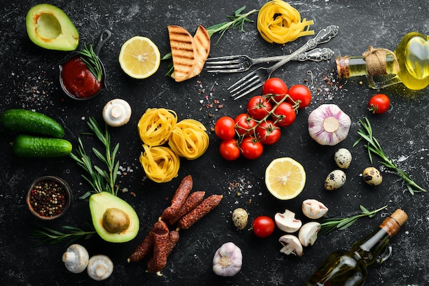 Foto trockene nudeln und zutaten zum kochen schwarzer lebensmittelhintergrund freier platz für ihren text