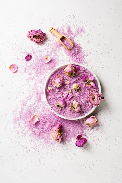 Trockene Rosenblüten und rosafarbenes Salz Wellness- und Körperpflege-Flachlagekonzept auf Draufsicht des weißen Hintergrundkopierraums