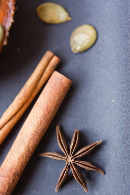 Trockene Sternanis-Zimtstangen und Kürbiskerne auf schwarzem Hintergrund Gemütliche Herbstdekorationen mit Naturdingen