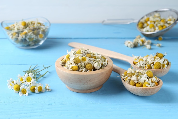 Foto trockene und frische kamillblumen auf einem hellblauen holztisch