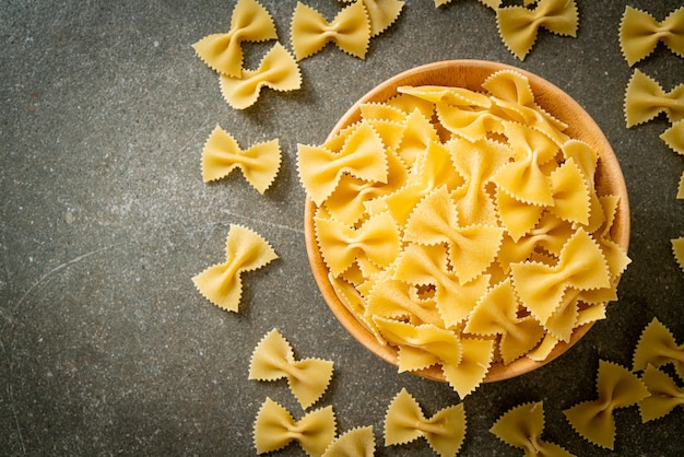 Trockene ungekochte Farfalle-Nudeln in Holzschüssel