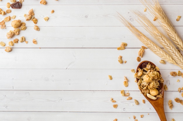 Trockenes Frühstück mit Haferflocken, Granulat und Nüssen. Müsli auf einem Leuchttisch in einem Holzlöffel und Ohren