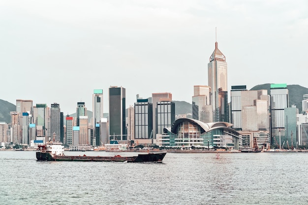 Trockenfrachtschiff im Victoria Harbour in Hongkong bei Sonnenuntergang. Blick von Kowloon auf HK Island.