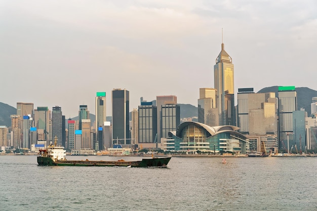 Trockenfrachtschiff im Victoria Harbour in Hongkong bei Sonnenuntergang. Blick von Kowloon auf HK Island.
