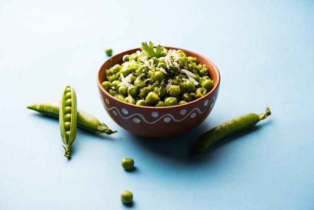 Trockenrezept mit grünen Erbsen oder Matar Ki Sookhi Sabji, serviert in einer Servierpfanne oder Terrakottaschüssel. Selektiver Fokus