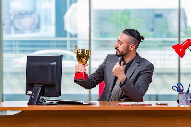 Trofeo de copa ganador de hombre de negocios en la oficina