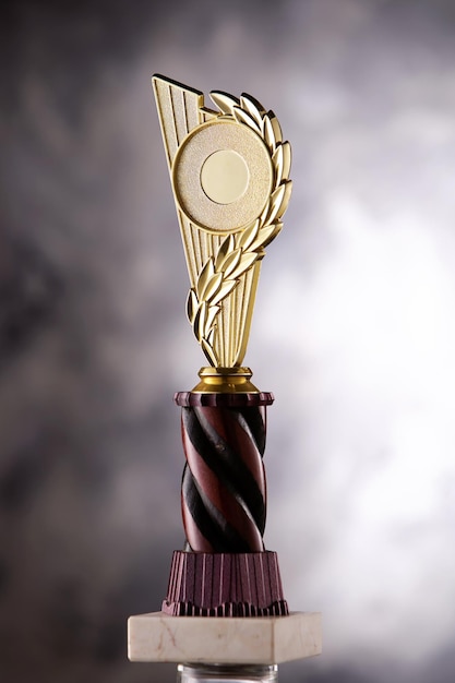 El trofeo de oro del campeón colocado sobre un fondo gris para el concepto ganador