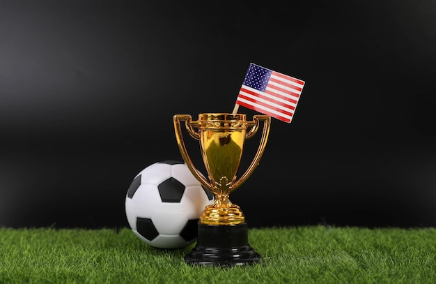 Trofeo de oro y pelota de fútbol con bandera de los Estados Unidos