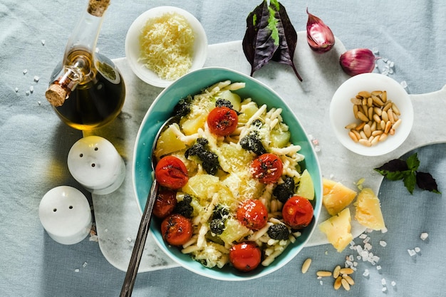 Trofeo de pasta italiana con tomates cherry fritos con patata y pesto de albahaca cocina tradicional saludable