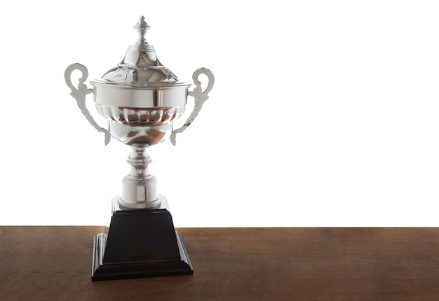 Trofeo de plata en mesa de madera.