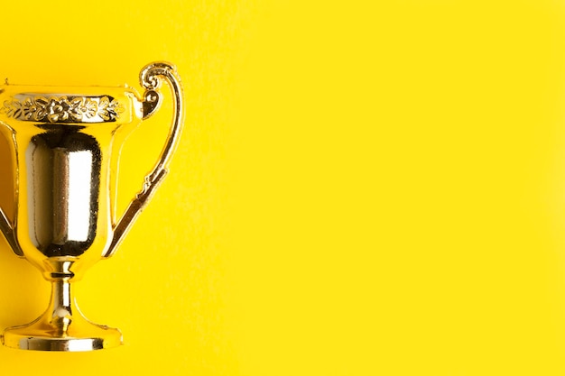 Foto troféu de conquista de vencedores de ouro em um fundo amarelo