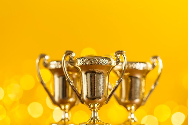 Foto troféu de prêmio de ouro contra fundo amarelo brilhante com luzes desfocadas