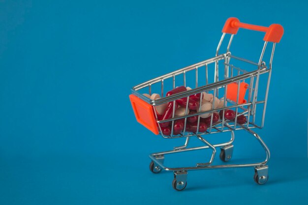 Trolley de concepto médico con medicamentos en azul medicamentos para el coronavirus covid 19 vitaminas para aumentar la inmunidad farmacia en línea
