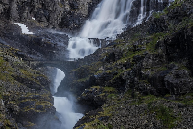 Trollstigen Road, na Noruega, com cachoeira de ponte de pedra e penhascos dramáticos