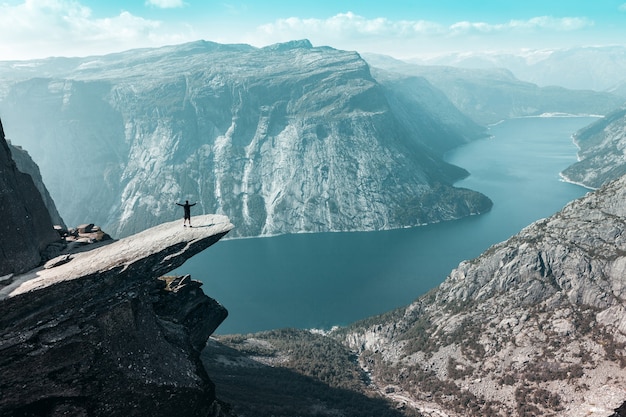 Trolltunga en Noruega con un hombre que abrió los brazos