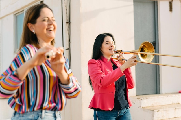 Foto la trombonista y la flautista se ríen en un ensayo