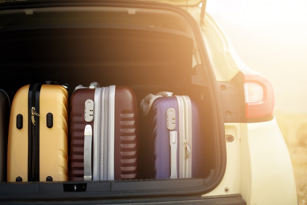 Tronco de coche abierto lleno de maletas en efecto luz solar.