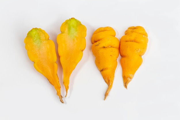 Tropaeolum tuberosum cortado na mitad em fondo blanco