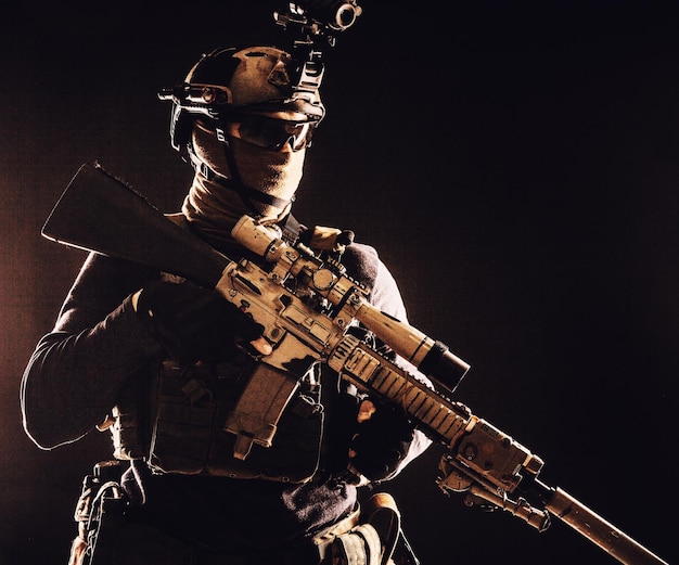 Tropas de élite del ejército francotirador de las fuerzas de operaciones especiales con máscara y gafas de visión nocturna o dispositivo de imagen térmica infrarroja en el casco con rifle de servicio con mira óptica y silenciador