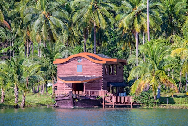 Tropenhaus in Form eines Schiffes neben dem Meer im Dschungel mit grünen Palmen Luxus-Strandresort auf einer Insel in Thailand Natur- und Reisekonzept