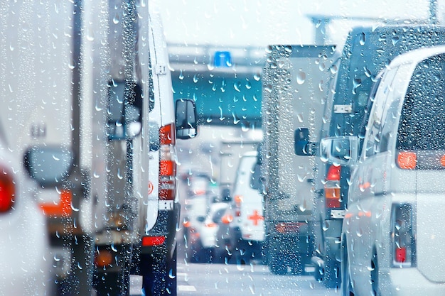 Tropfen auf Glas Autostraße Regen Herbstnacht / abstrakter Herbsthintergrund in der Stadt, Autoverkehr, romantische Fahrt mit dem Auto