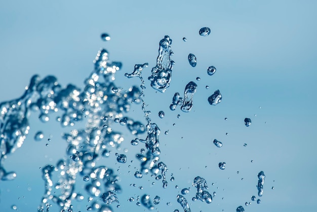 Tropfen blaues Wasser des Brunnens in den Himmel