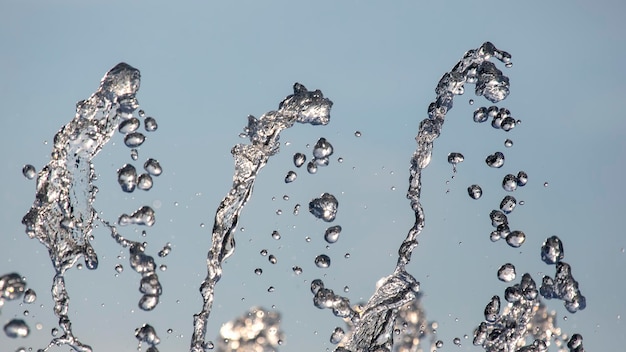 Tropfen blaues Wasser des Brunnens in den Himmel