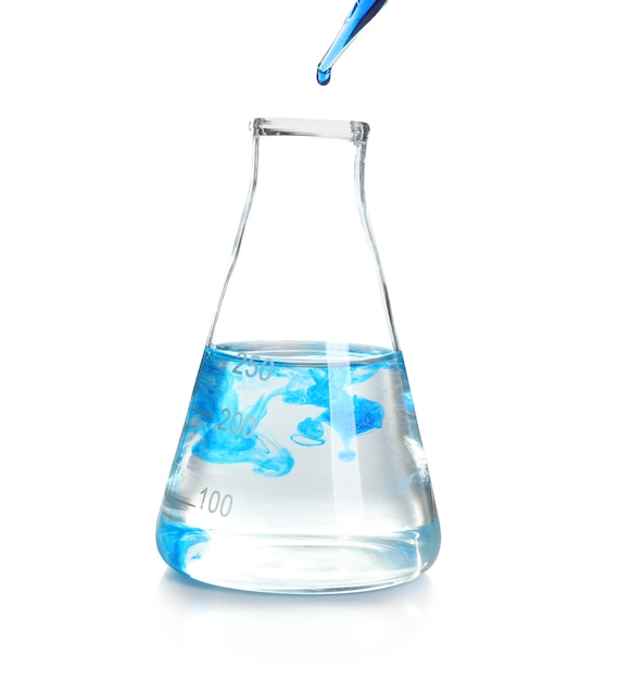 Tropfende blaue Flüssigkeit in Laborglas auf weißer Oberfläche