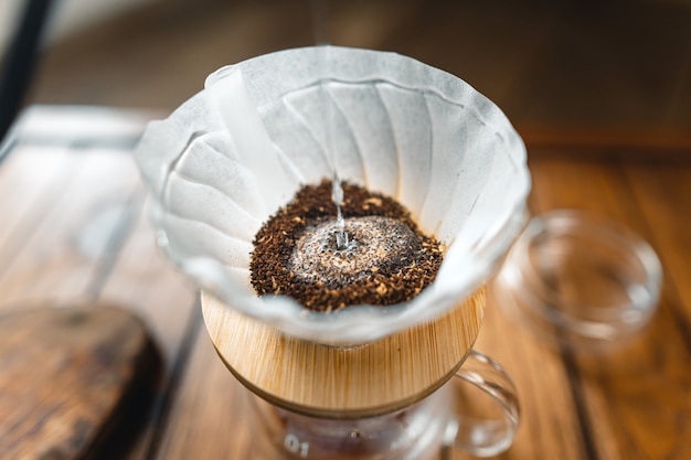 Tropfender Kaffee und langsamer Kaffee zu Hause, heißes Wassertropfen im Kaffee