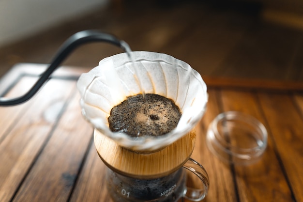 Tropfender Kaffee und langsamer Kaffee zu Hause, heißes Wassertropfen im Kaffee