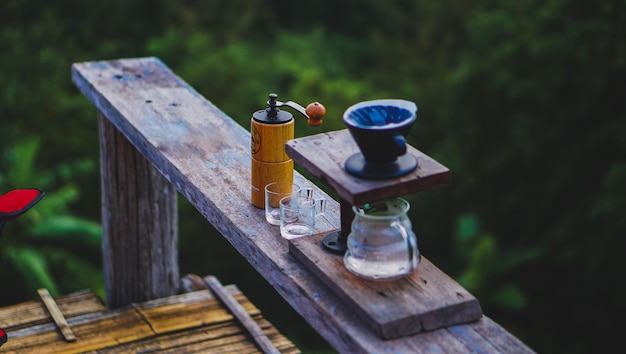 Tropfkaffeeset auf Holztisch mit Berglandschaft auf dunklem Ton