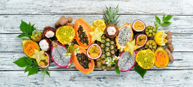 Tropische Früchte auf weißem Hintergrund: Papaya, Mangostan, Kaktusfrucht, Pytahaya, Ananas. Ansicht von oben. Freier Platz für Text.