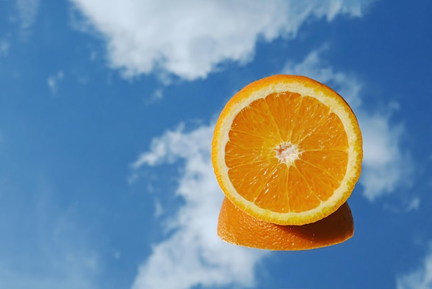 Tropische Orange der orange Zitrusfrucht auf Hintergrund des blauen Himmels und der Wolken